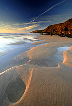 Sandymouth bay (National Trust) at low tide, Cornwall, UK, with pools in sand left by retreating tide