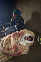 Zulu woman and her baby in a typical Zulu hut, Hidden Valley, KwaZulu-Natal, South Africa