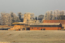 Warham village, farm buildings and church in hoar frost, North Norfolk, England, UK, February