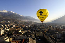Hot air balloon in flight over the centre of Aosta City, northern Italian Alps