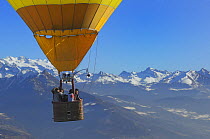 Passengers taking photographs of the dawn landscape on a hot air balloon in flight over the Aosta Valley region of the northern Italian Alps