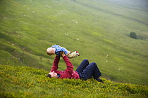 Man lifting child in the Vale of Ewyas, Brecon Beacons National Park, Powys, Wales