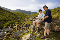 Walkers reading map at Llyn y Fan Fach, Brecon Beacons National Park, Powys, Wales