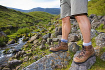 Close-up of walker's legs and walking boots at Llyn y Fan Fach, Brecon Beacons National Park, Powys, Wales