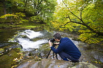 Photographer taking photo of  waterfall along the Nedd Fechan, Brecon Beacons National Park, Powys, Wales