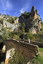 Two cyclists on a bridge over a gorge in the Alto Tajo Natural Park, Guadalajara, Spain