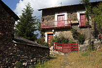 House with red doors and balconies. Alendo in the Pyrenees mountains, Catalonia, Lerida, Spain