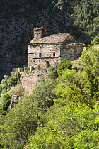 Romanesque hermitage clinging to the hillsides of Arboló in the Pyrenees mountains. Catalonia, Lerida, Spain