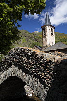 Bridge and church bell tower in Isil, the Pyrenees mountains, Catalonia, Lerida, Spain