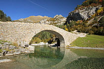 Bridge over the clear water over a river in Bujaruelo Valley, Ordesa y Monte Perdido National Park. The Pyrenees, Huesca, Spain