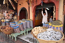 Man closing the shutters to his shop in the medina of Marrakech, Morocco December 2007
