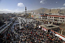 Tibetan pilgrims prostrate themselves in front of the Jokhang Temple in Lhasa, the holiest temple in Tibetan Buddhism. In the background stands the Potala Palace, the former residence of the Dalai Lam...