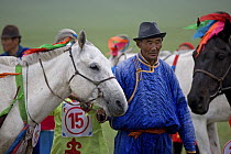 Mongolian man with his horse at the annual Nadam horse race, Inner Mongolia. June 2006