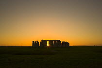 Sun setting in winter behind Stonehenge, Salisbury Plain, Wiltshire, UK