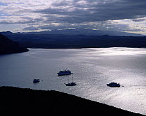 Evening light over boats moored in the sound between Bartolome Island and Isabela Island (background), Galapagos