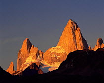 The towering jagged summits of Poincenot and Mount Fitz Roy (Chalten) lit up by the sunrise in Glaciers National Park, Argentina