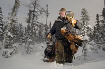 Trapper carrying his catch of one wolverine and four pine martens through the taiga of Manitoba, at -45 degrees C. Canada.