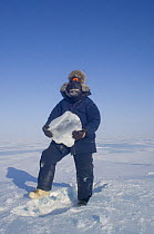 Photographer Steven Kazlowski holding an ice block that will be melted for drinking water. Arctic coast, eastern Arctic National Wildlife Refuge, Alaska, 2007