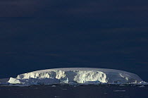 Sunlight illuminates the shear faces of a large iceberg along the western Antarctic peninsula, Southern Ocean