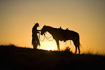 Silhouetted cowboys at sundown. Model Released #234.