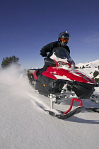 Snowmobiling through fresh powder snow. Togwotte Pass, Bridger-Teton National Forest, Wyoming, USA, Model released
