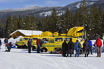 Tourists loading onto snow coaches at Flagg Ranch, South entrance to Yellowstone National Park, Wyoming, USA