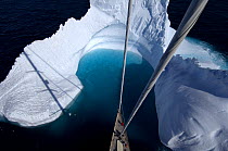 Aerial view, taken from the mast, of SY "Adele"'s bow in the bay of an iceberg, Portal Point, Reclus Pennisula, Antarctica, January 2007 Non editorial uses must be cleared individually.