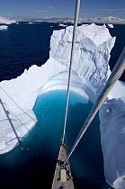 Aerial view, taken from the mast, of SY ^Adele^'s bow in the bay of an iceberg, Portal Point, Reclus Pennisula, Antarctica, January 2007 Non editorial uses must be cleared individually.