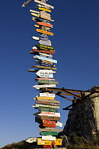 Signs erected by soldiers (and more recently tourists) marking the direction and distance to their home towns - know locally as the Totem Pole. Port Stanley, Falkland Islands, January 2007