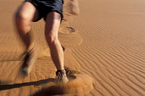 Person running through sand leaving footprints behind, sand dunes in the Namib-Naukluft NP, Namib desert, Namibia