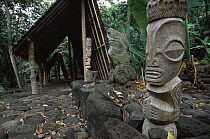 Polynesian archeaological site in Hatiheu, Nuku Hiva Island, with ancient stone platform and some modern replicas of carvings. Marquesas Islands, French Polynesia