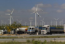 Juxtaposition of lorries and tankers and wind farm, Castille, Spain