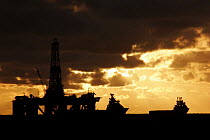 Silhouette of supply vessels and an oil rig in the North Sea, September 2006