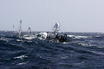 A fishing vessel hidden between wave troughs whilst trawling for cod in the North Sea, June 2007