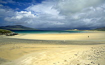 Lone person on beach at Seilbost at low tide, looking across to Taransay, Isle of Harris, Outer Hebrides, Scotland, UK