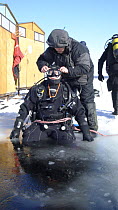Diver preparing to dive under ice in the White Sea, Northern Russia  March 2008