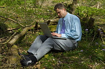 Man working on laptop on Natural environment for business course at the Avon Wildlife Trust Folly Farm Centre, Somerset, UK Model released