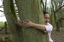 Theraputic tree-hugging at the Avon Wildlife Trust Folly Farm Centre, Somerset, UK. Model released