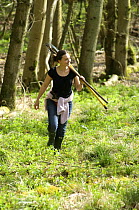 Volunteer carrying rakes on wildlife training course at the Avon Wildlife Trust Folly Farm Centre, Somerset, UK. Model released