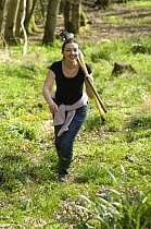 Volunteer carrying rakes on wildlife training course at the Avon Wildlife Trust Folly Farm Centre, Somerset, UK. Model released