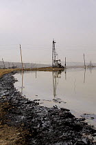 Oil Well and beam pump with pollution in subsidence lagoon, Baku, Azerbaijan, February 2008