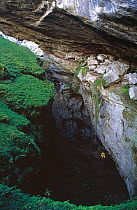 Potholer being lowered down into underground cave system, Boca del Mortero de Astrana, Ason, Cantabria, Spain, February 1998