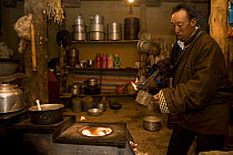 Man preparing sacrificial fire with juniper, Dargye, Sichuan, Tibet, China