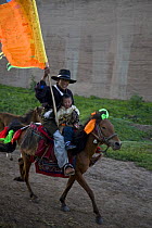 Man and boy riding horse to holy mountain, Dargye, Sichuan, Tibet, China