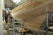 Shipwrights fairing the hull of Bristol Channel Pilot Cutter "Morwenna". RB Boatbuilding, Underfall Yard, Bristol Floating Harbour, England. July 2008, Model Released