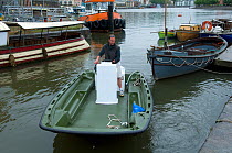 Man reversing his dory / landing craft in Bristol Floating Harbour, UK    , July 2008