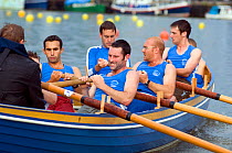 Strained faces on bow side as Bristol Pilot Gig Club's Men's crew practice in their gig "Isambard" on Bristol's Floating Harbour, UK. July 2008, Model Released