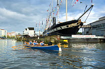 Bristol Pilot Gig Club's Ladies crew practicing in their gig "Isambard" on Bristol Floating Harbour, with the city skyline and Brunel's SS Great Britain steamship in the background. England, UK. July...