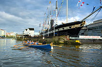 Bristol Pilot Gig Club's Ladies crew practicing in their gig "Isambard" on Bristol Floating Harbour, with the city skyline and Brunel's SS Great Britain steamship in the background. England, UK. July...