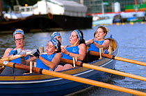 Strained faces as Bristol Pilot Gig Club's Ladies crew practice in their gig "Isambard" on Bristol Floating Harbour, England, UK. July 2008, Model Released